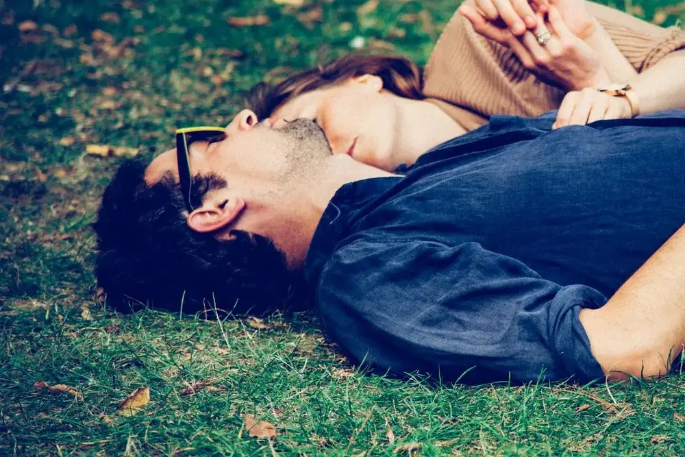 Man and woman lying on the grass in a park