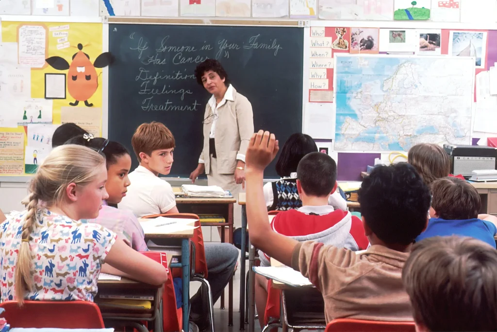 student raising his hand in a colorful classroom