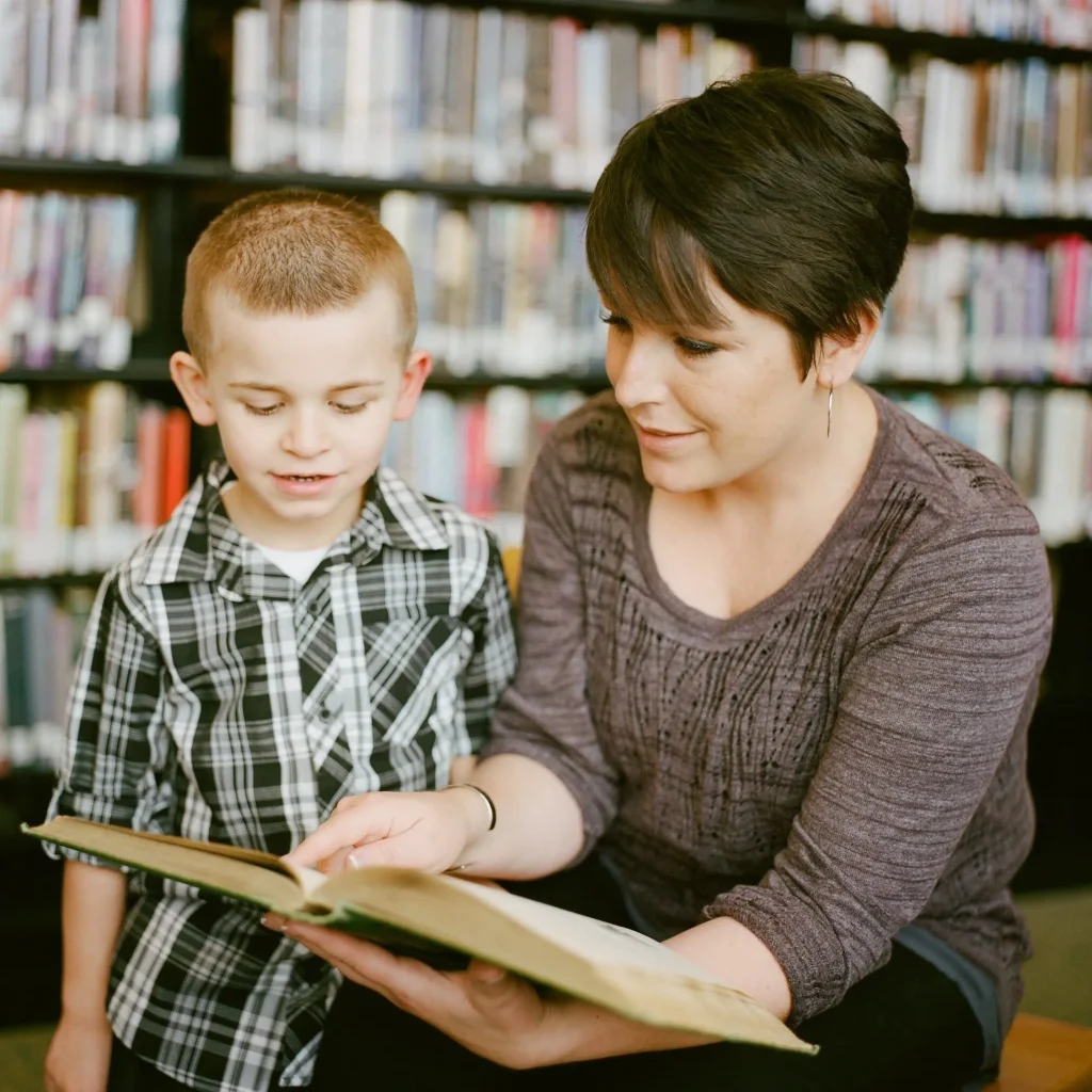 adult showing a book to a child