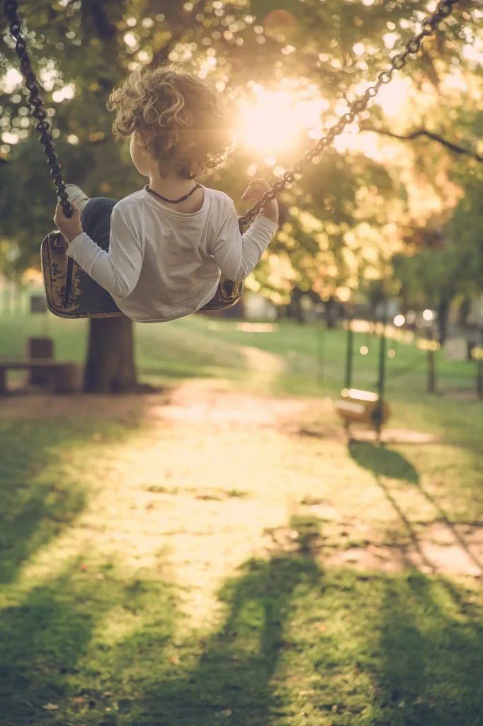 child playing on a swing set in a park