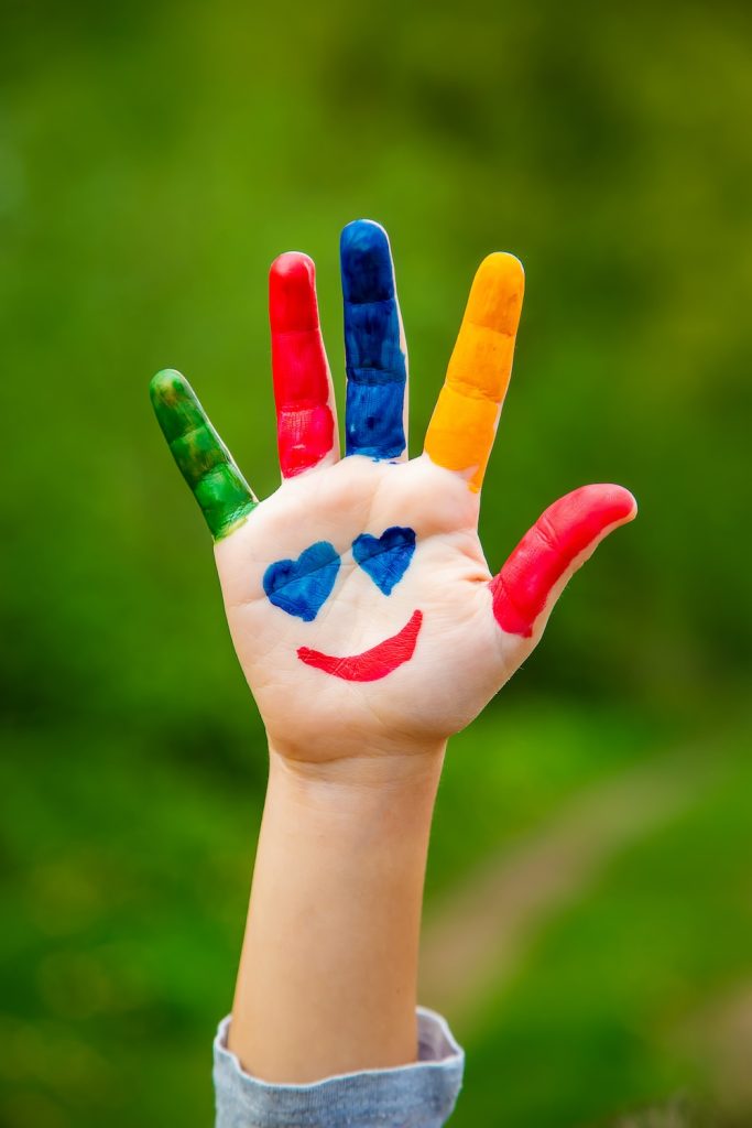 Smile painted on the hands of a child.