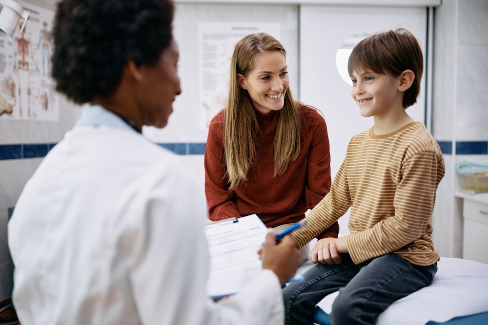 Mother and child happily talking with doctor