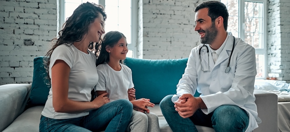 Doctor talking to young child and mother.