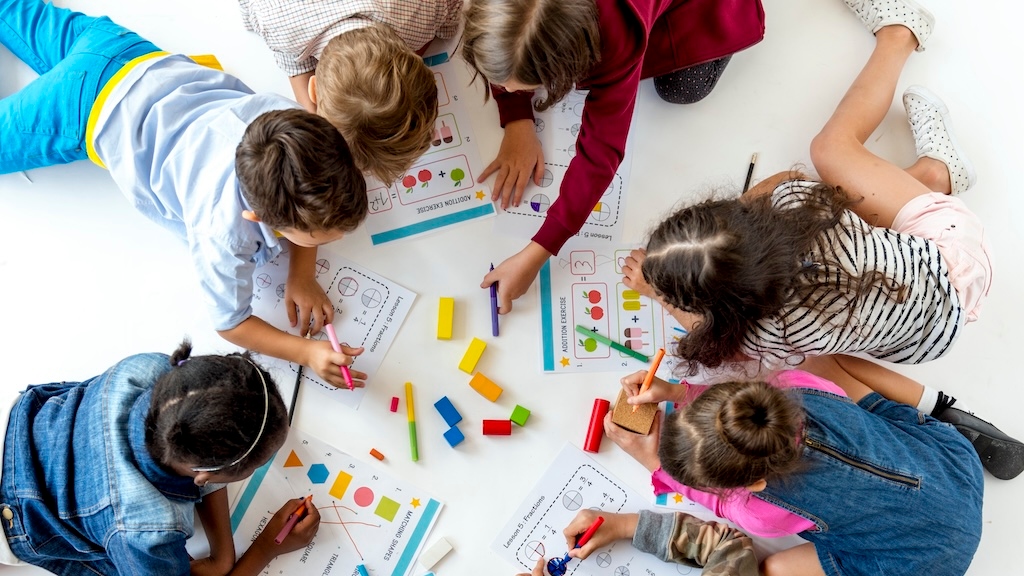 Group of kids writing and studying math