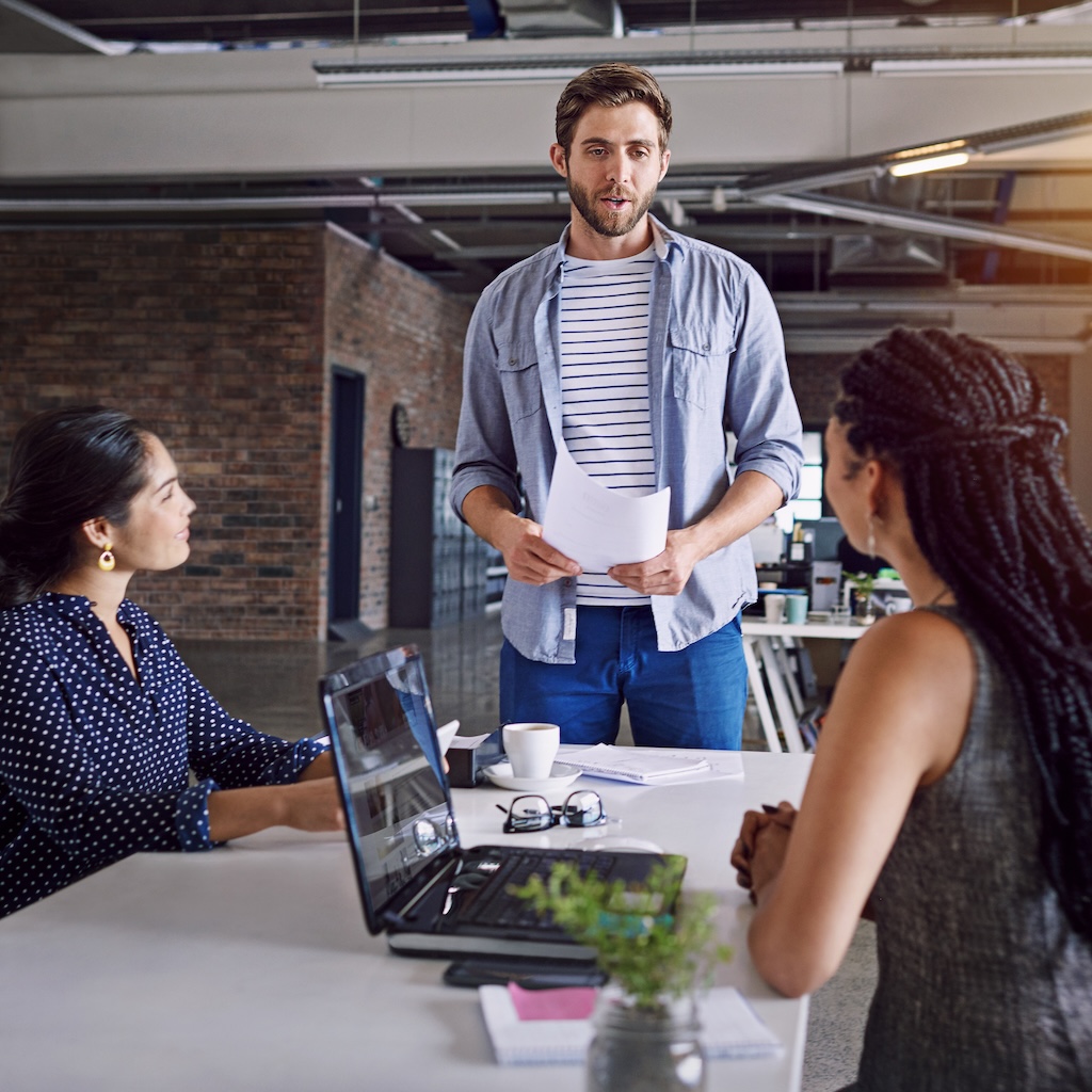 Man speaking to coworkers in the office