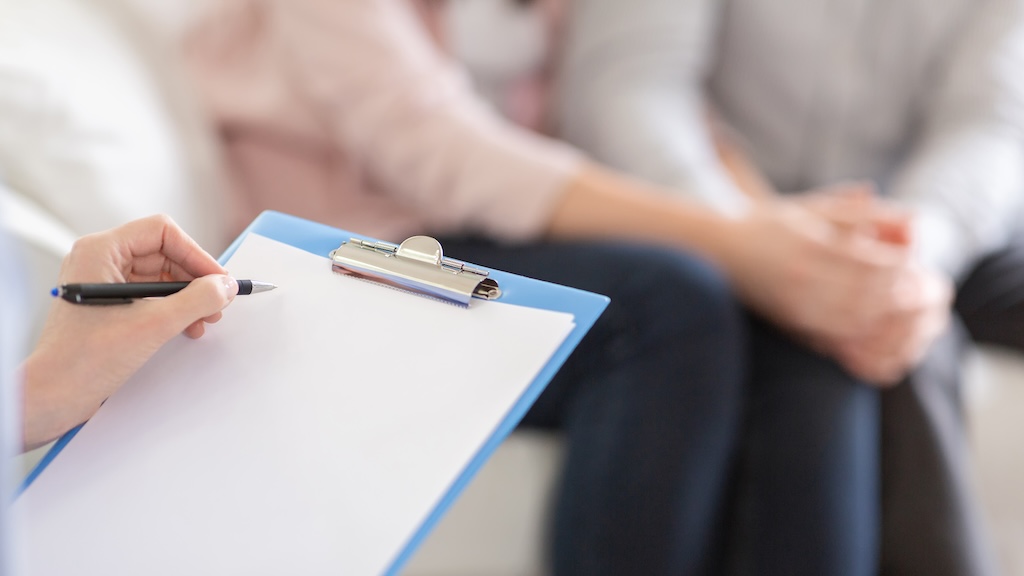 Psychotherapist writing in blank notepad