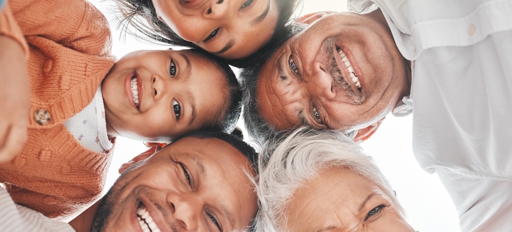 Huddles in the sunlight. Low angle shot of an affectionate family of five huddled on the beach