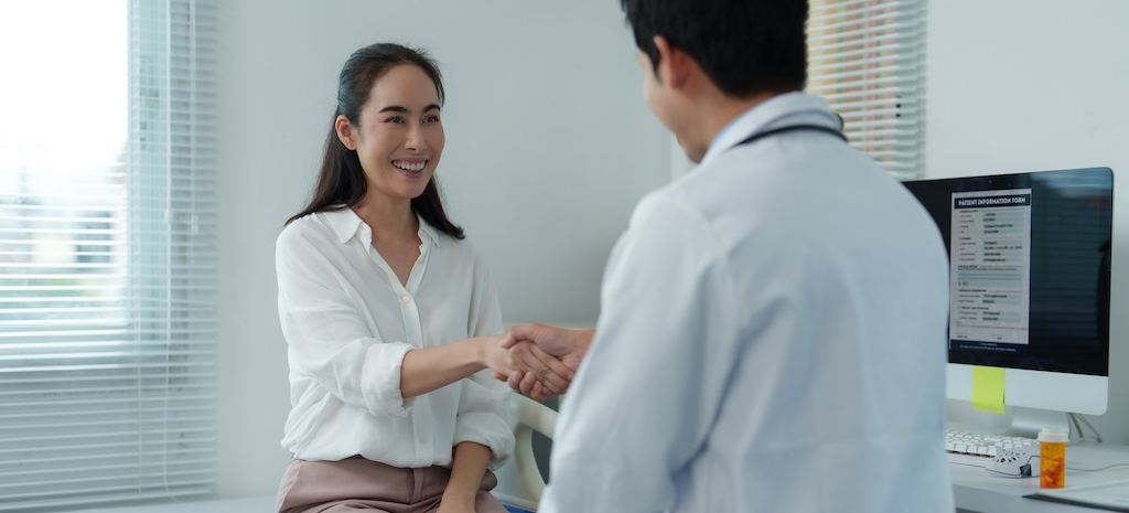 Doctor shaking hands with happy patient