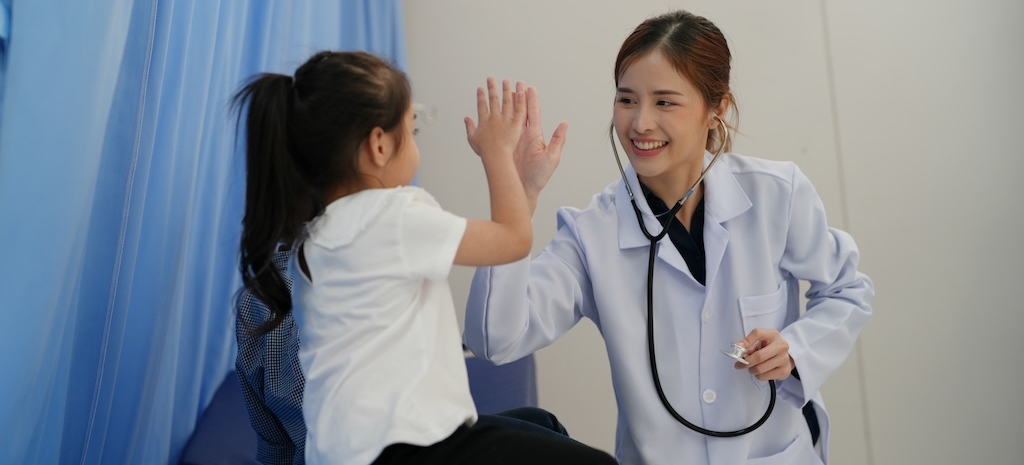 Doctor giving high five to child patient seeking autism testing and diagnosis