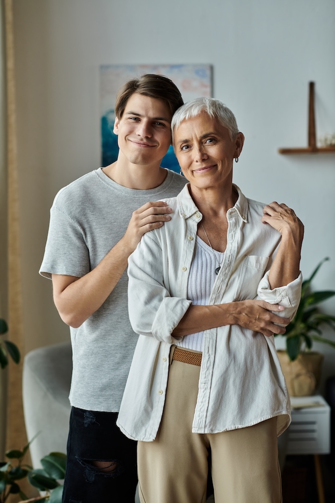 A joyful mother and son share a heartfelt embrace, celebrating their bond in a cozy living room.