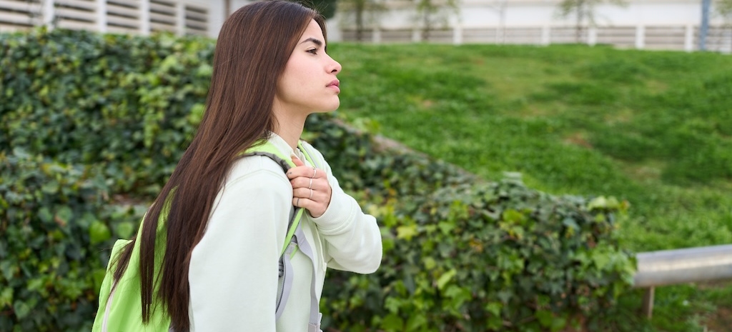 Side view of focused student walking on university campus