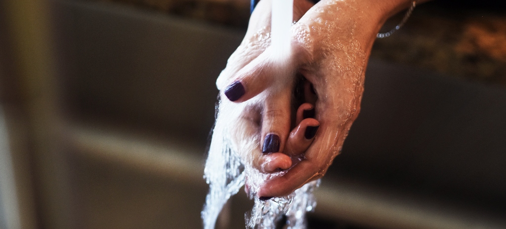 Photo of woman washing her hands in the sink
