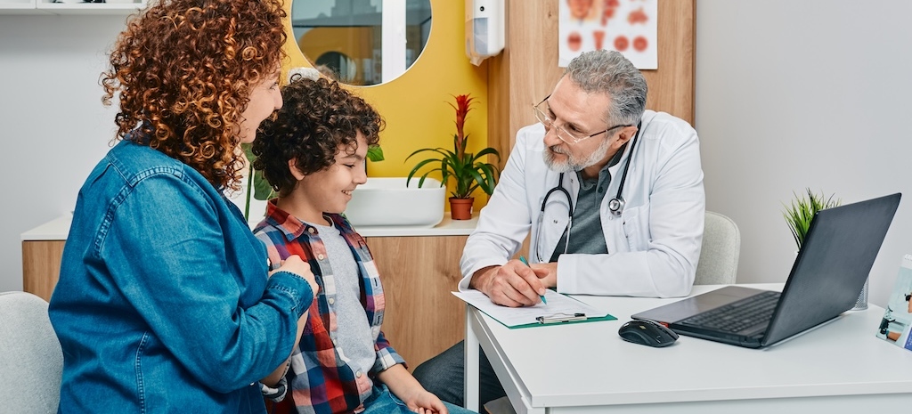 Friendly pediatrician communicate with her child patient at doctor's office while pediatrician consultation