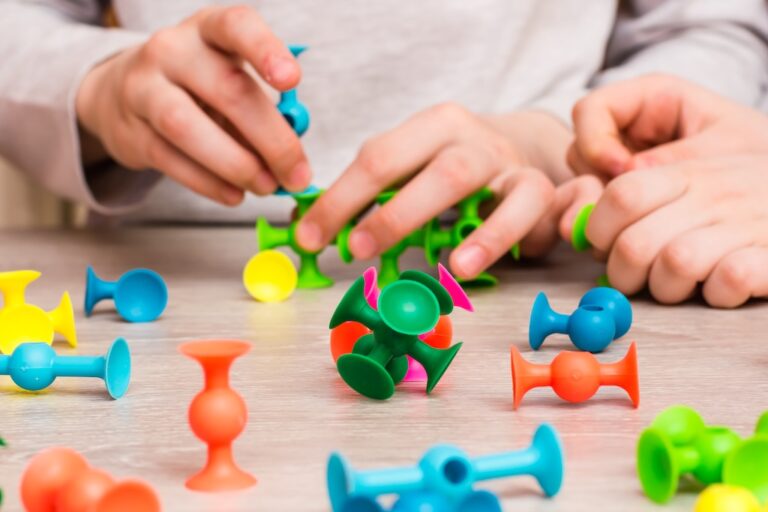 Children connect the details of the color designer on the table. Leisure of the child in confinement. The development of creative abilities