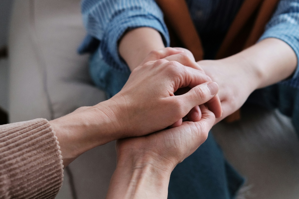 Clinician holding hands with client, representing our focused, compassionate approach to neuropsych testing in San Diego.