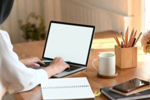 Individual working at a laptop with organized desk materials, representing executive functioning skills like focus, planning, and task management in a neuropsych context