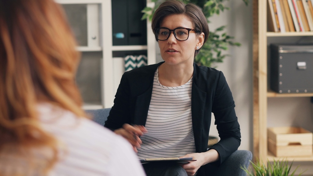 Clinician speaking with a client during professional and academic exam accommodations testing, representing a supportive neuropsychological evaluation setting for students and professionals.