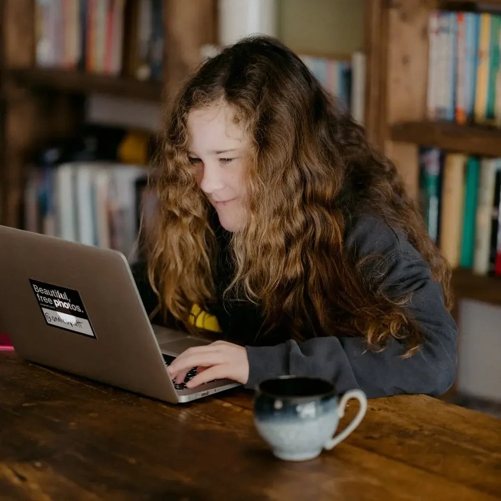 Learning Disabilities Young woman working on a laptop in a library