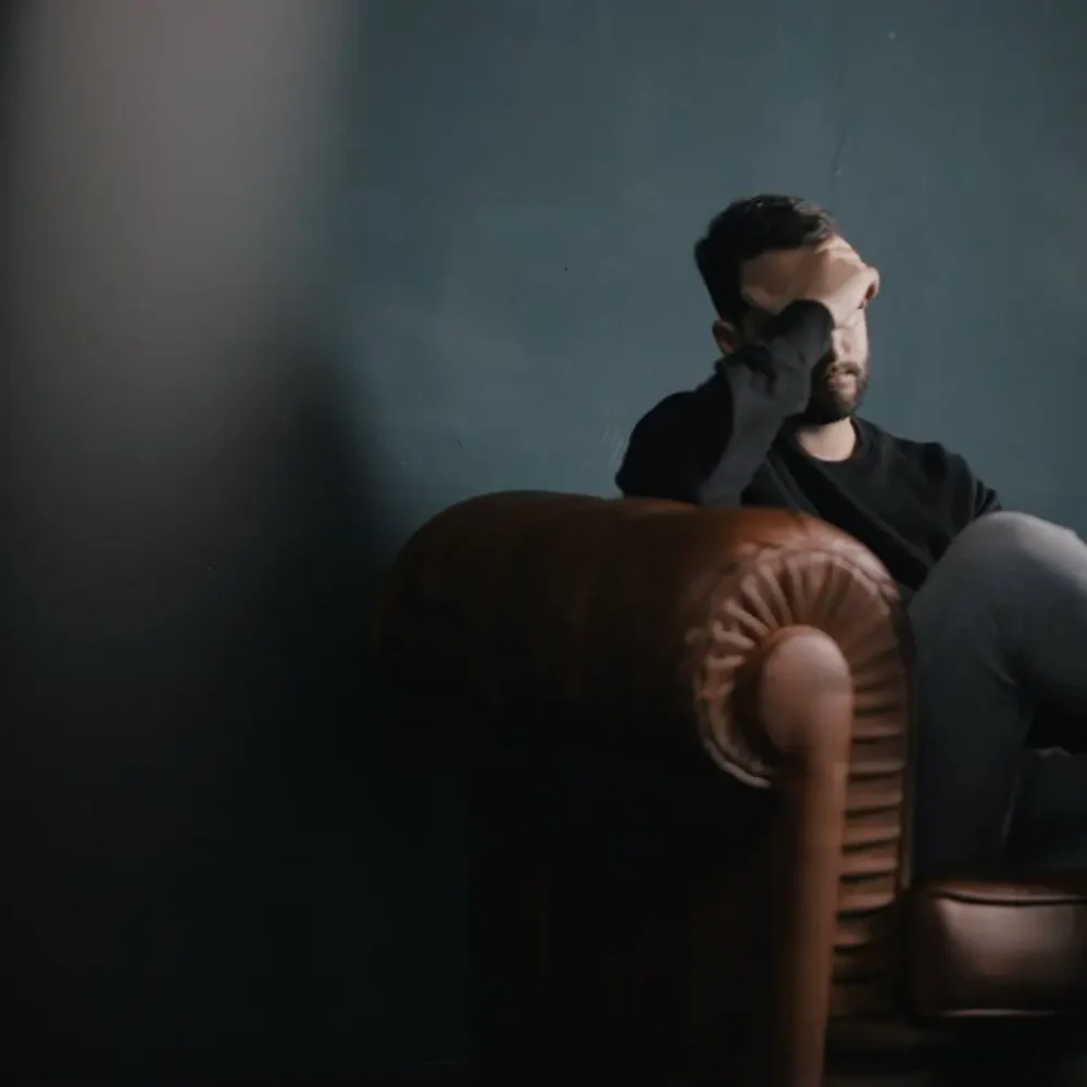 New Mental Health Diagnosis Young man sitting on a couch looking forlorn